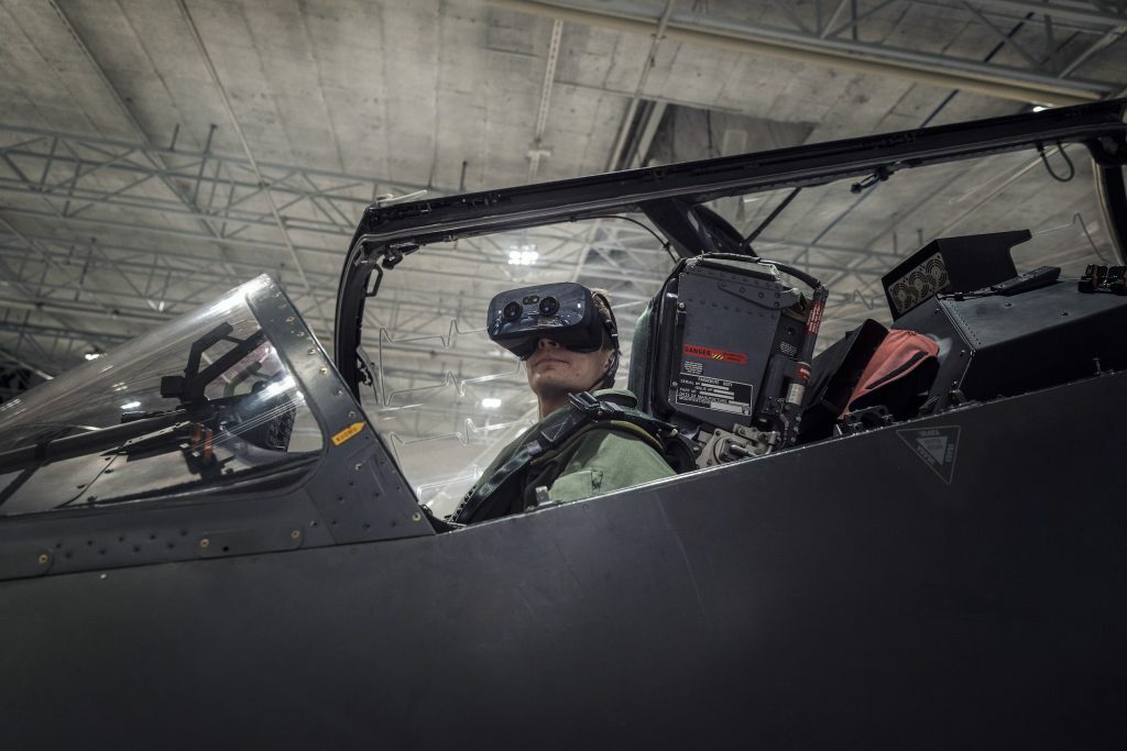 Pilot sitting inside fighter jet wearing a VR headset